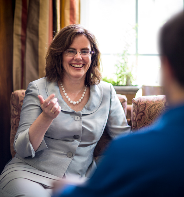 C. Elizabeth Leach in her office talking with an anonymous individual