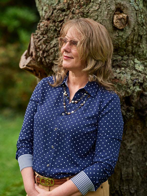 photo of C. Elizabeth Leach leaning on a tree and looking towards the sky