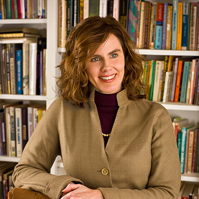 photo of C. Elizabeth Leach in her office standing in front of her bookshelf.